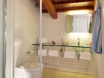 Il bagno della camera 11 si distingue dagli altri per il grande lavabo in vetro e i rivestimenti in resina
